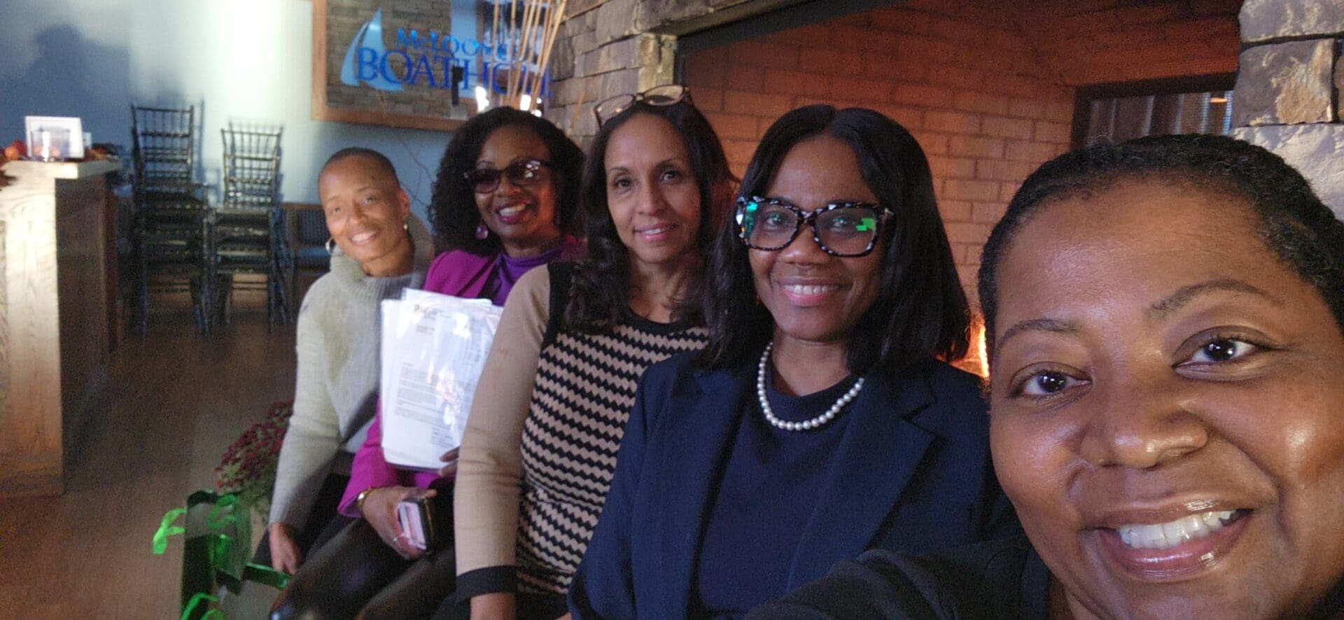 A group of women sitting in front of a fireplace.