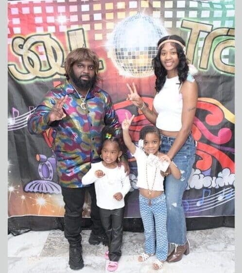 A family posing for a picture in front of a disco ball.