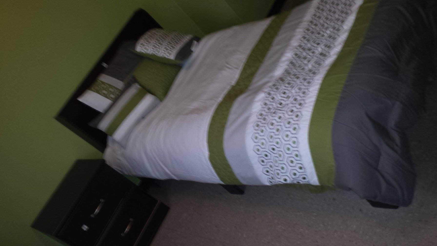 A bed with green and white sheets on it