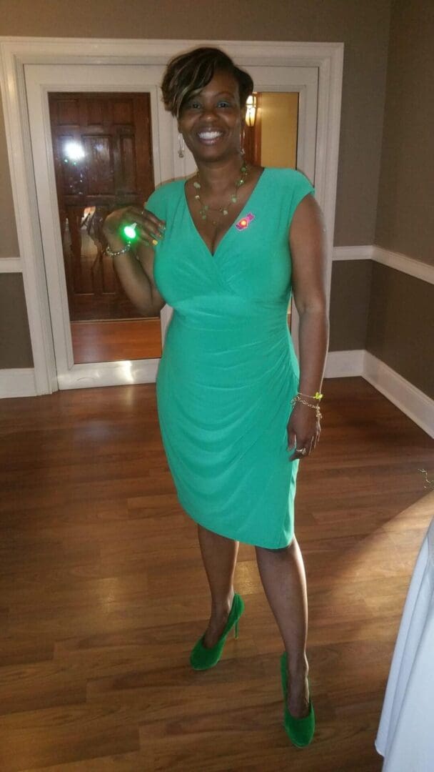 A woman in a green dress holding a light up wand.