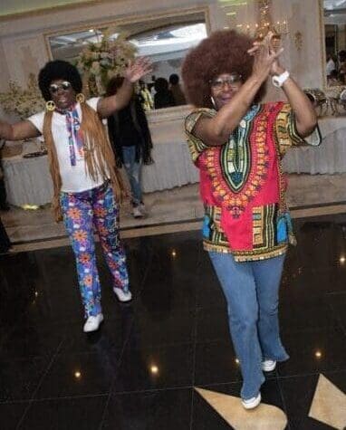 Two people dancing on a dance floor wearing costumes.