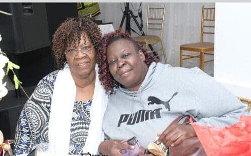 Two women sitting next to each other in a room.