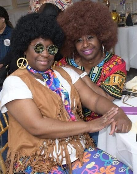 Two women dressed up as the 7 0 's