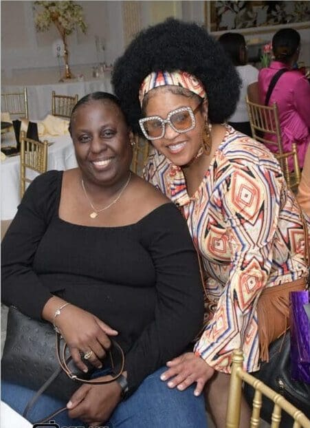 Two women posing for a picture at an event.