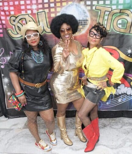 Three women in costumes posing for a picture.