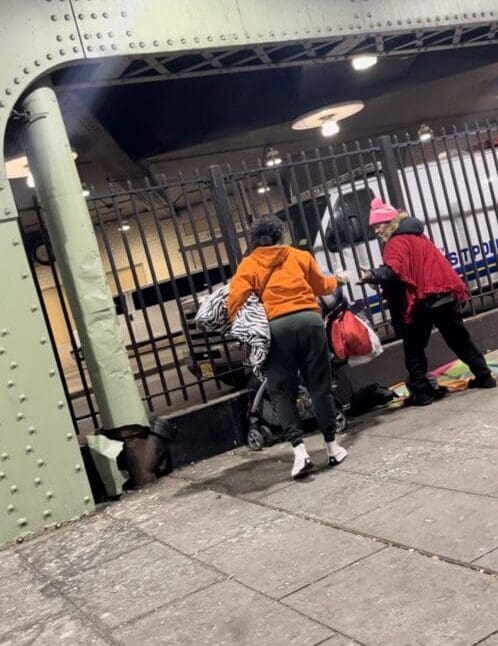 Two people are walking in a subway station.