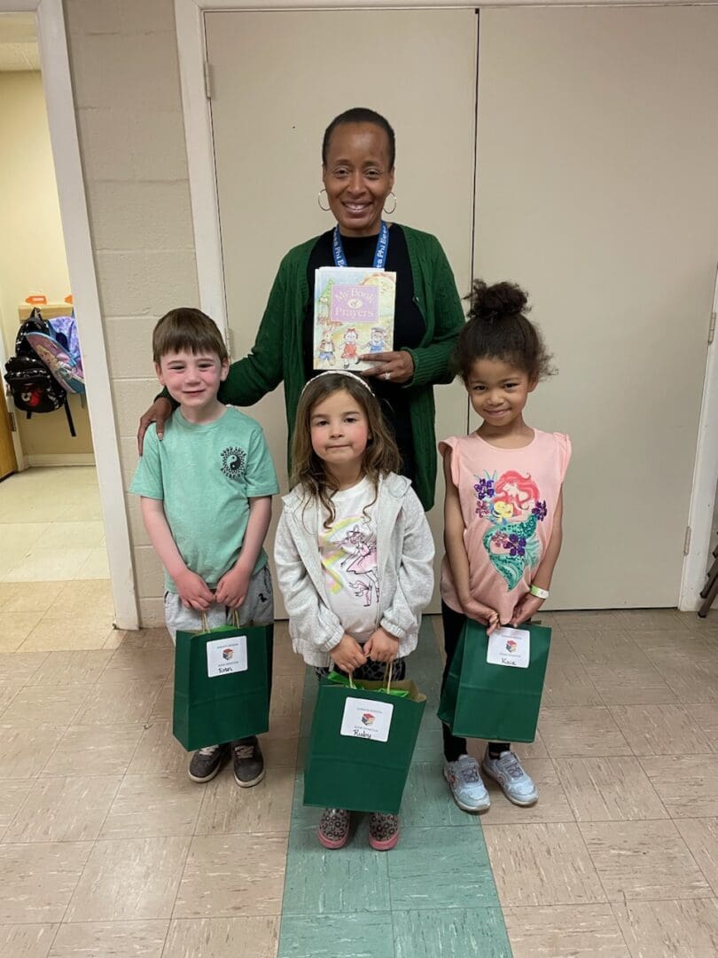 A woman holding a book with four children.