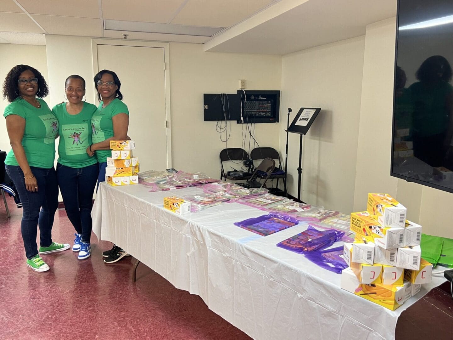 Two women standing in front of a table with boxes.