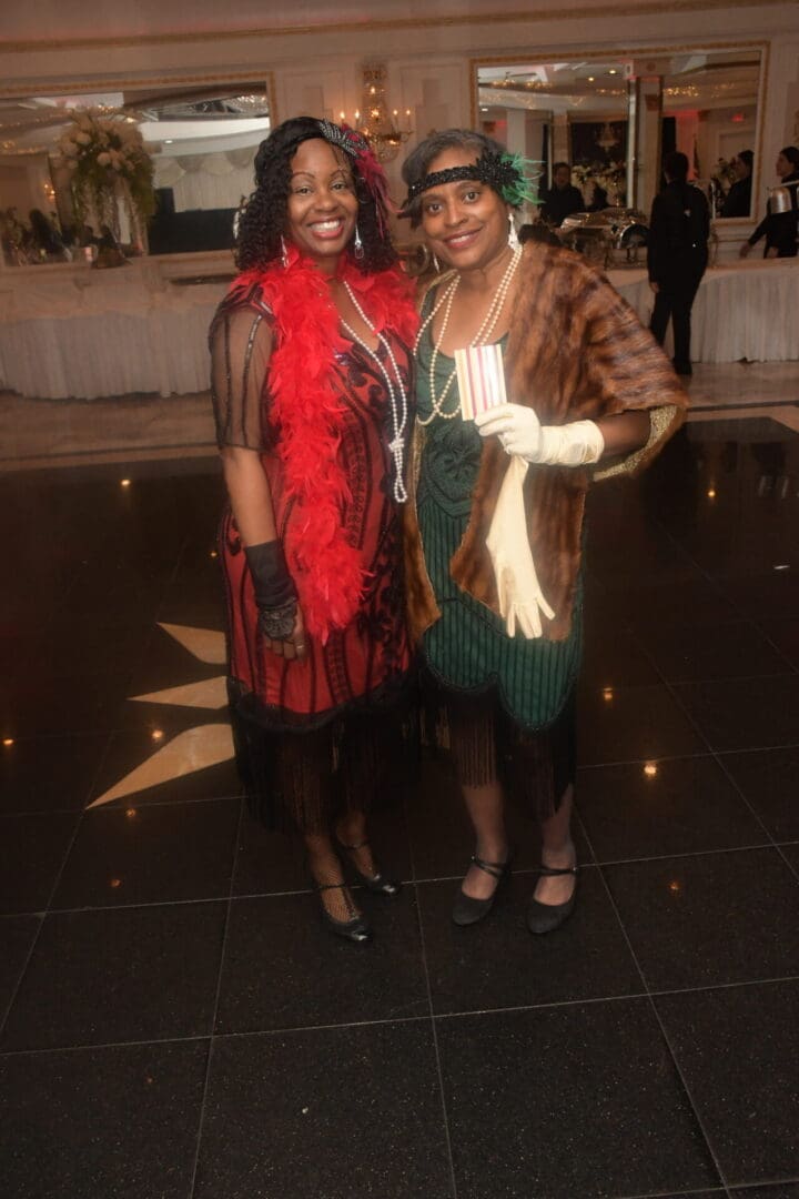 Two women in costumes pose for a picture.