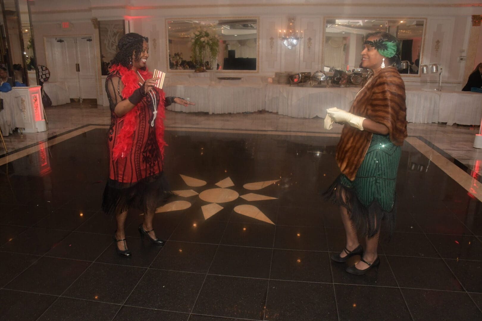 Two women are standing in a room with candles.