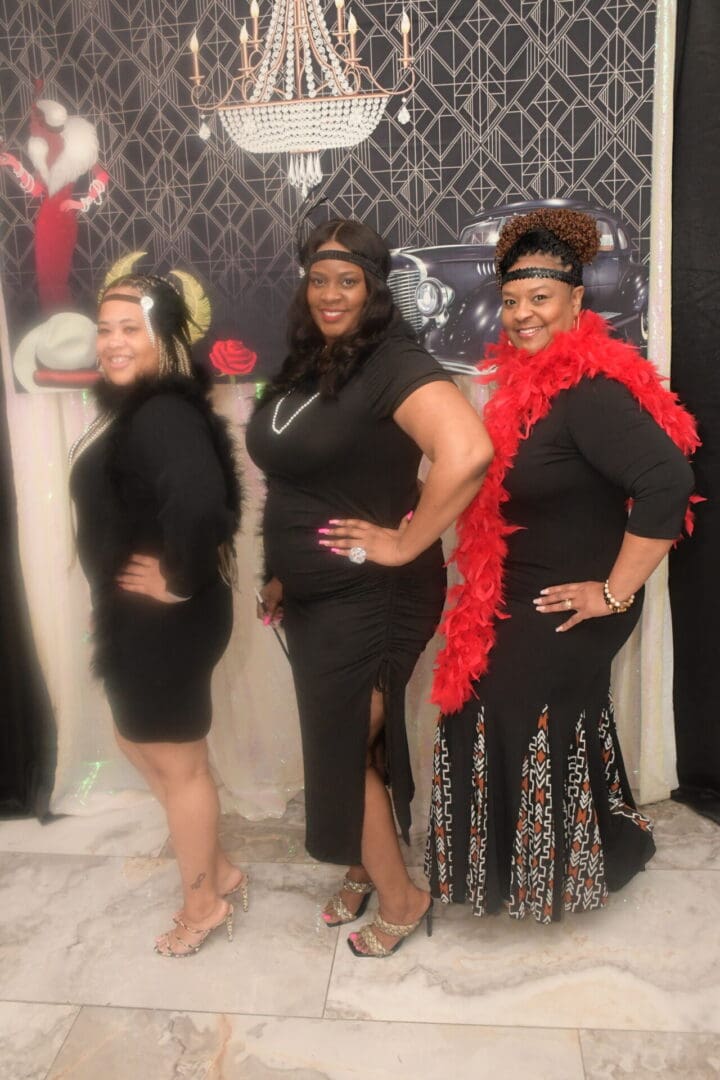 Three women in black outfits posing for a picture.