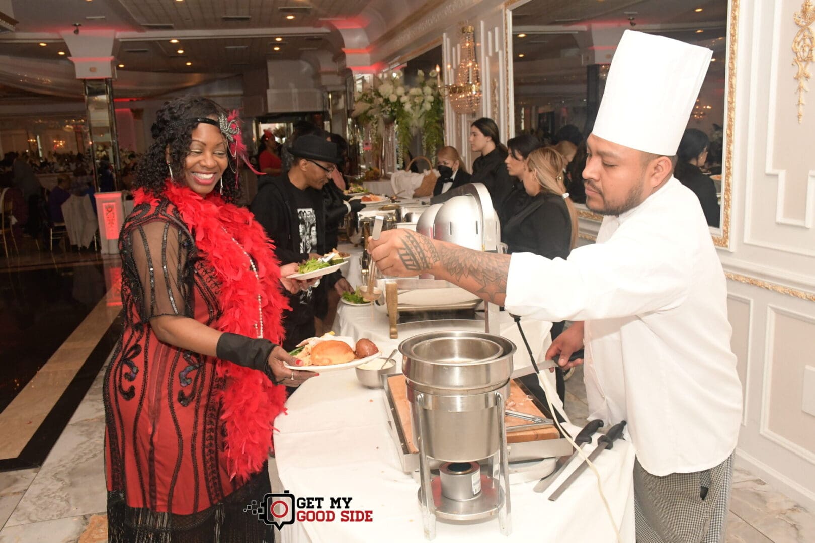 A man serving food to a woman at an event.