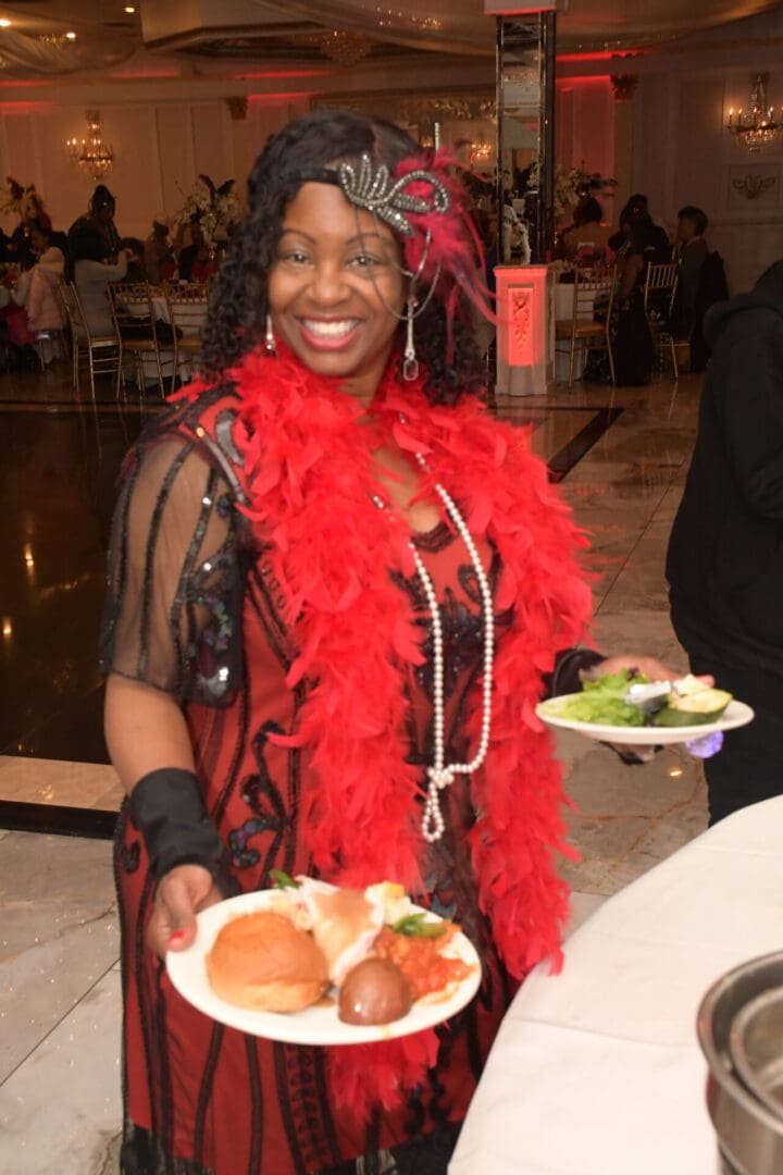 A woman holding two plates of food in her hands.