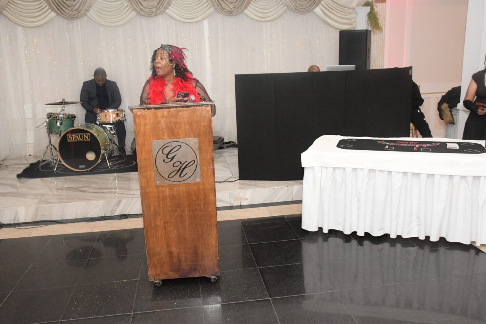 A woman standing at the podium in front of a stage.