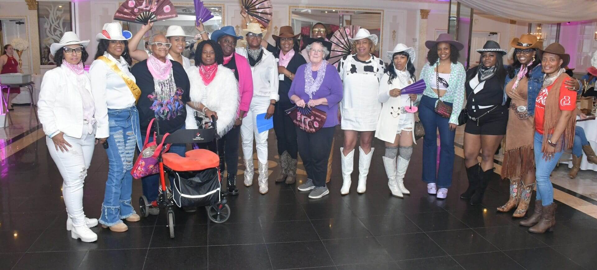 Group in cowboy hats at indoor event.
