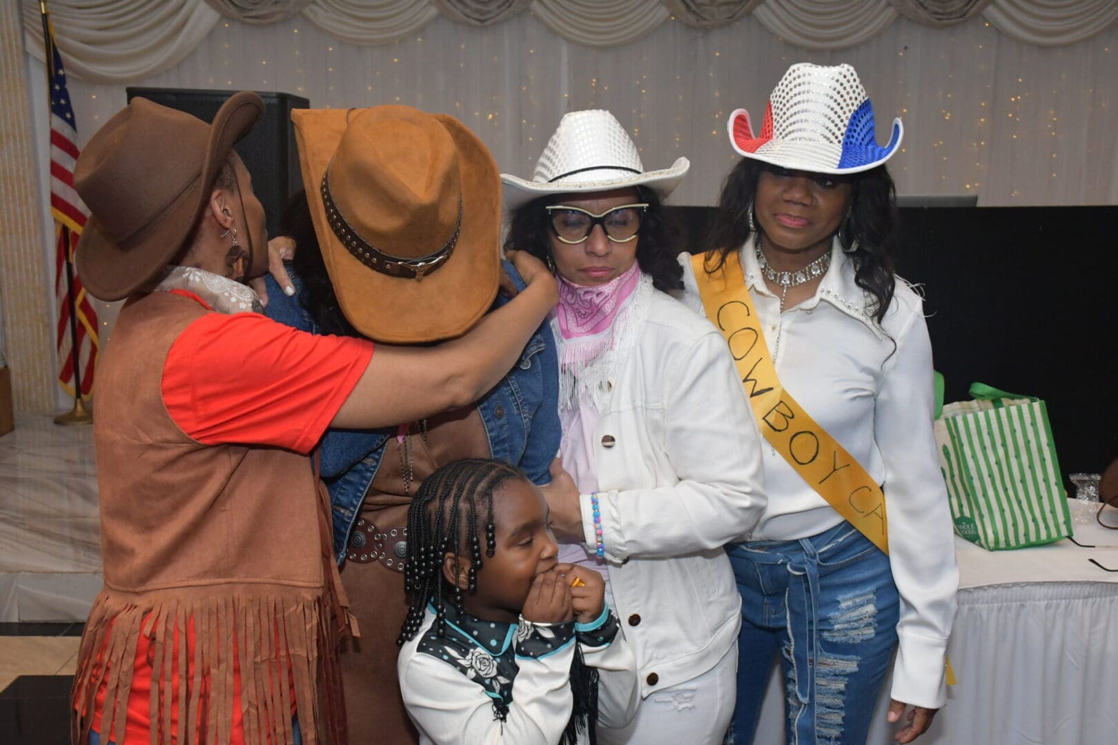 Group of people wearing cowboy hats indoors.