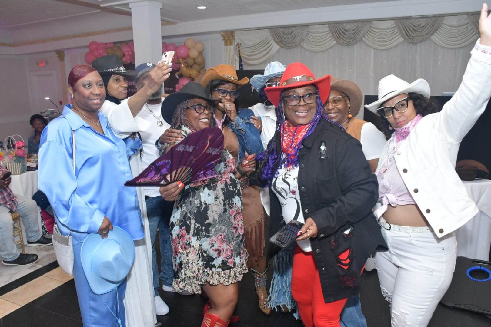 Group in cowboy hats posing together indoors.