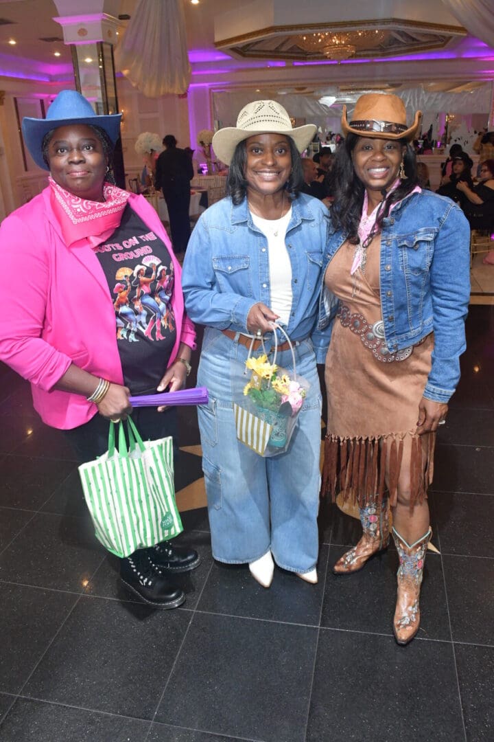 Three women in cowboy-themed attire smiling.