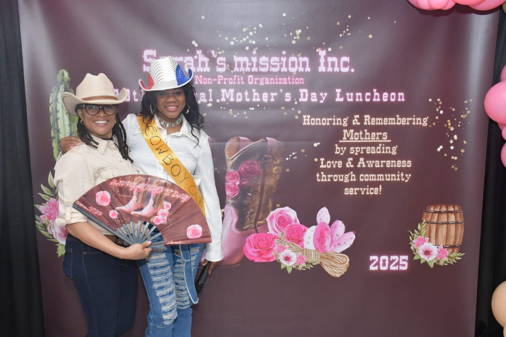 Two women posing at Mother's Day event.