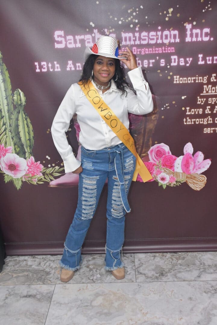 Woman in cowboy hat and sash smiling.
