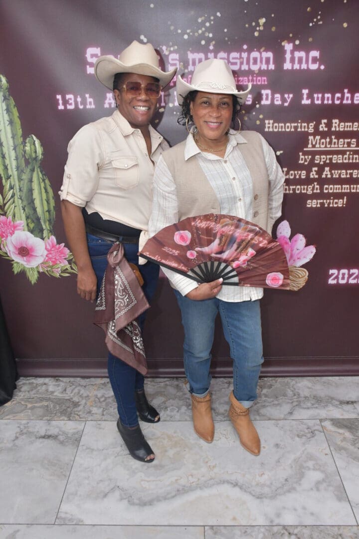Two people in cowboy hats smiling together.