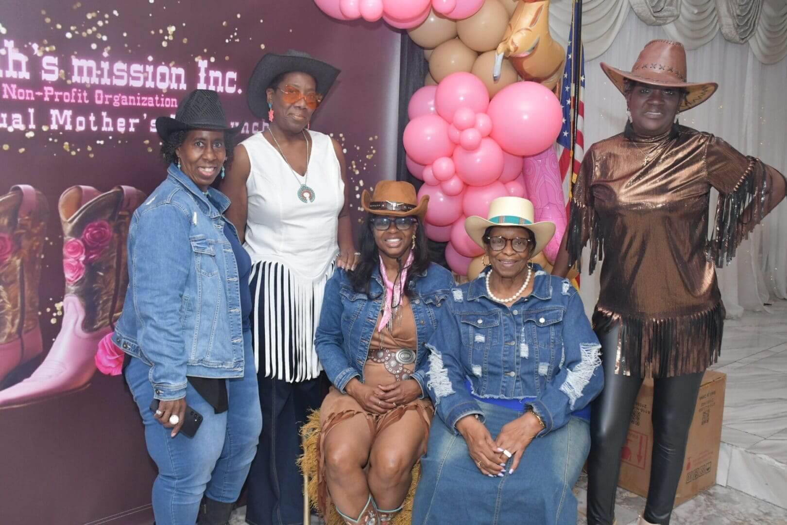 Group photo with cowboy hats and balloons.