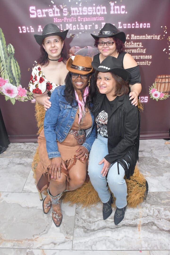 Four women in cowboy hats posing together.