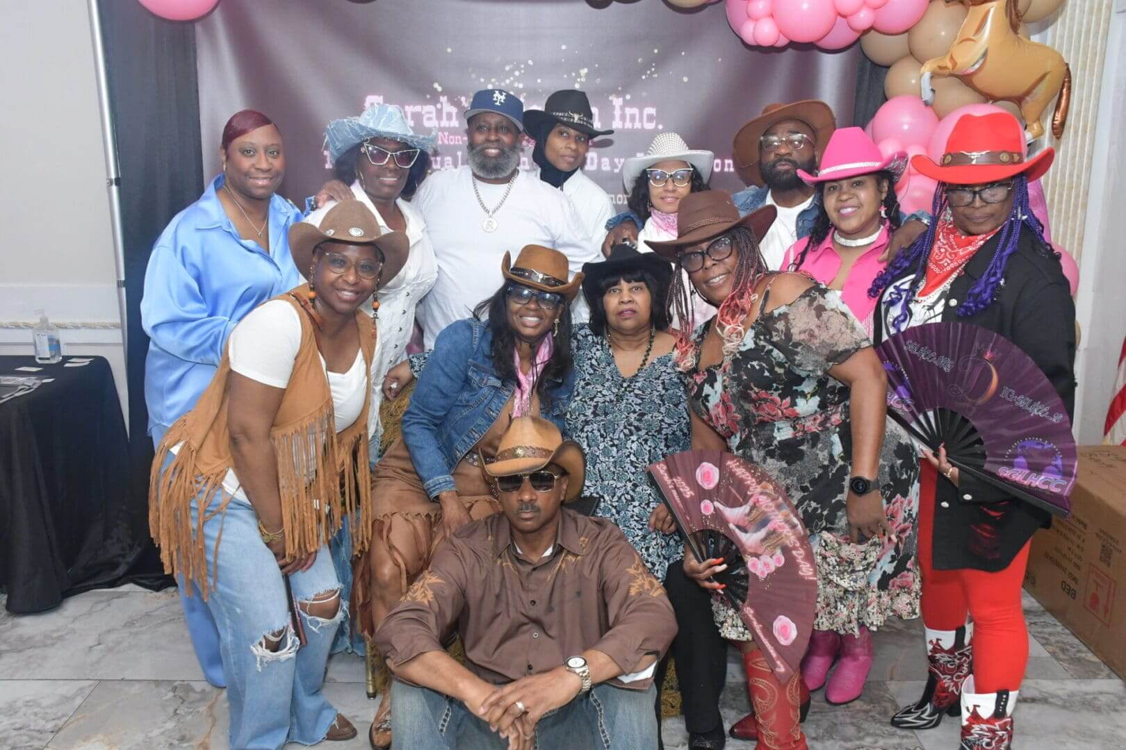 Group in cowboy attire posing together indoors.