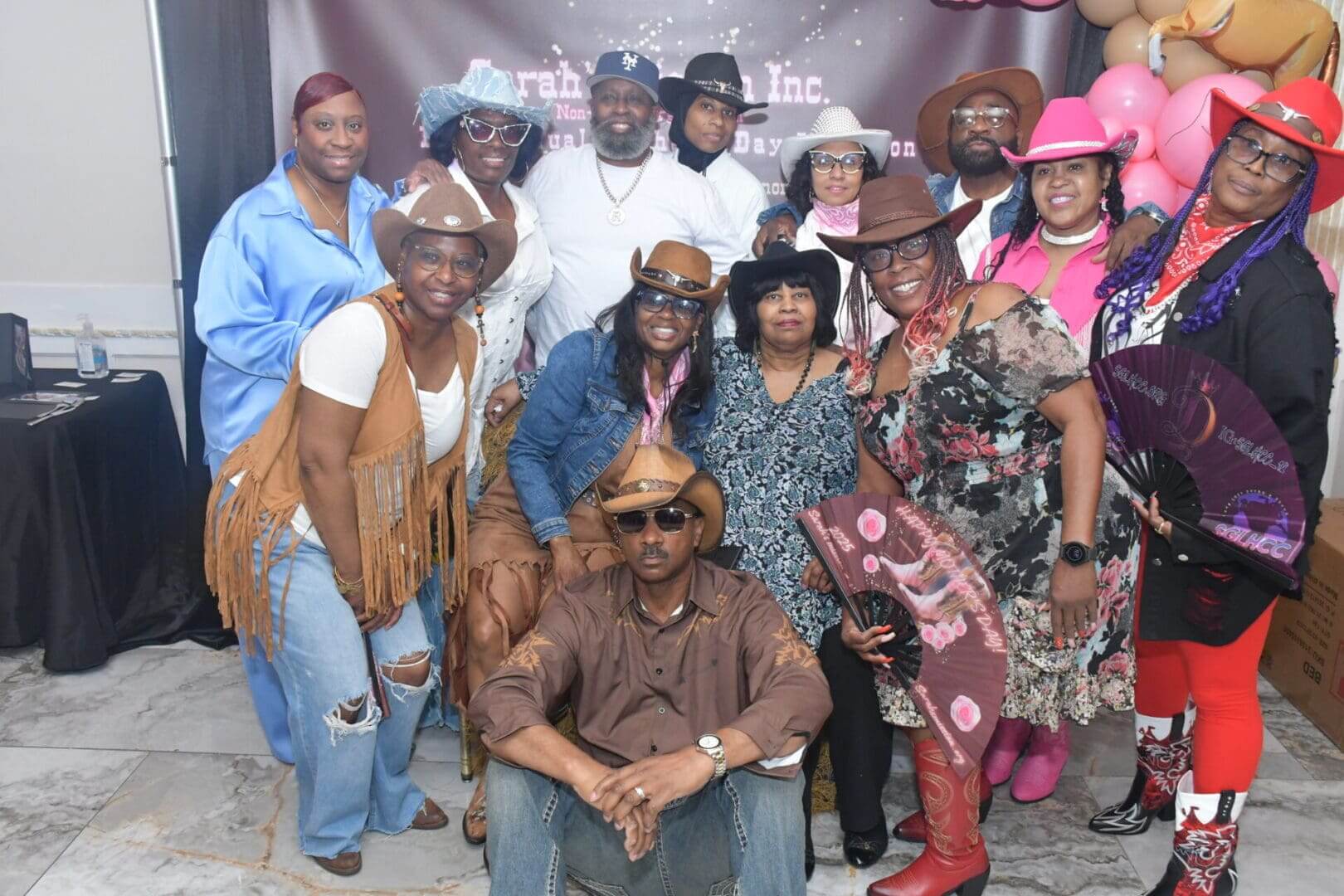 Group in cowboy hats posing together indoors.