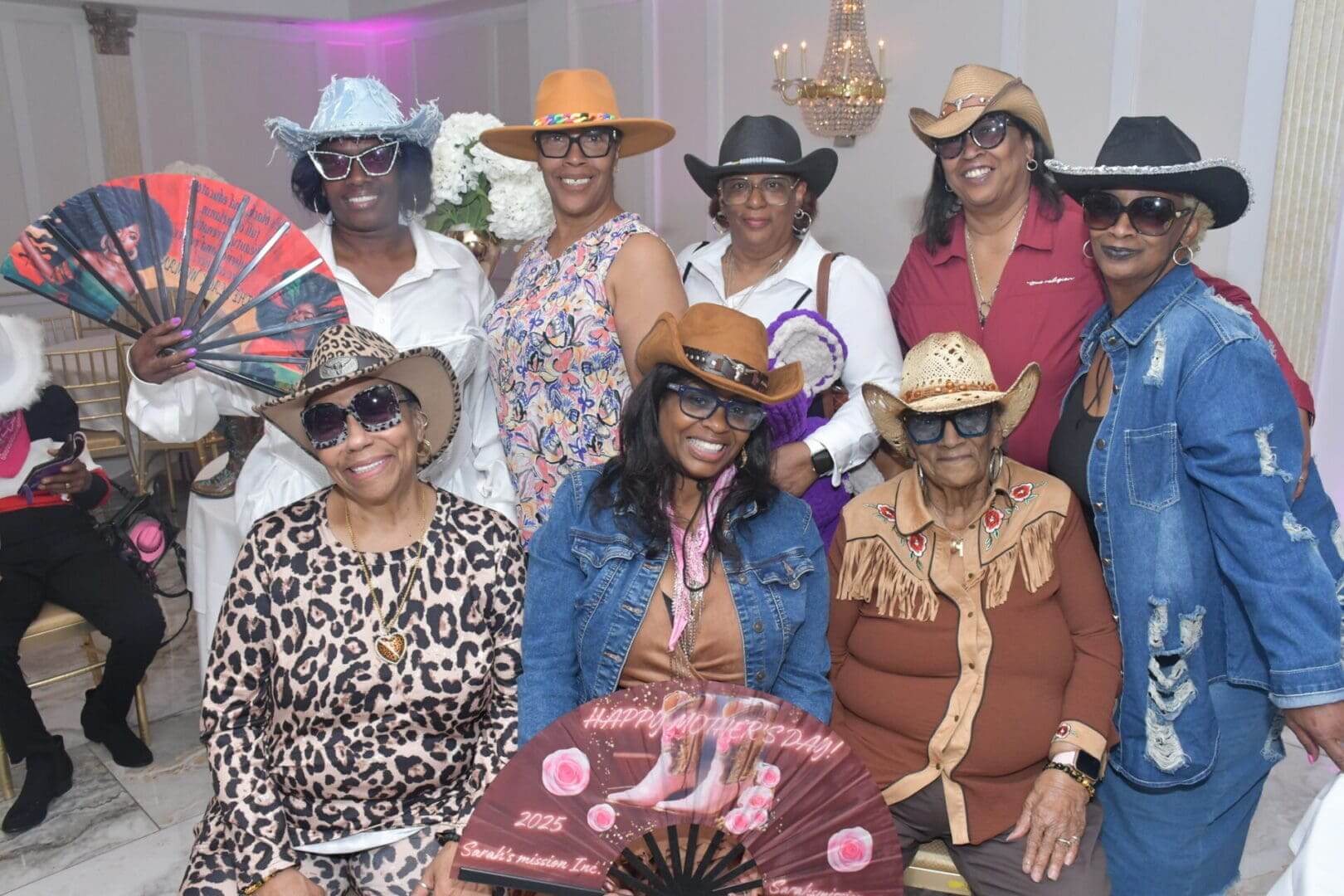 Group of women in cowboy hats smiling.