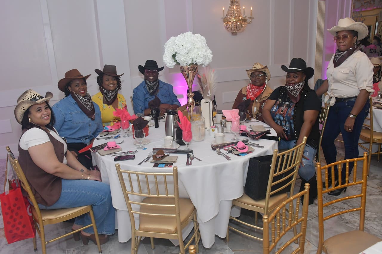 People in cowboy attire at a decorated table.