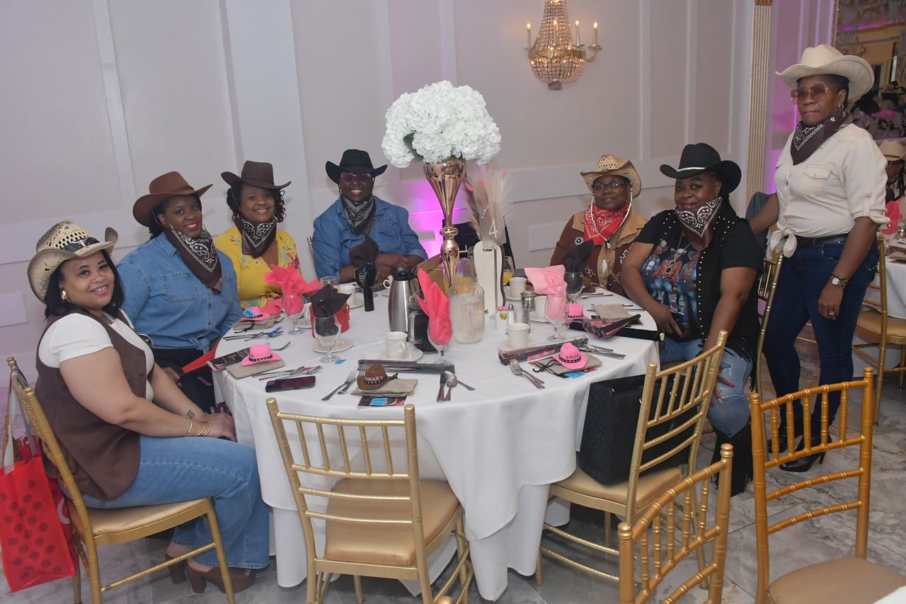 Group in cowboy hats at decorated table.