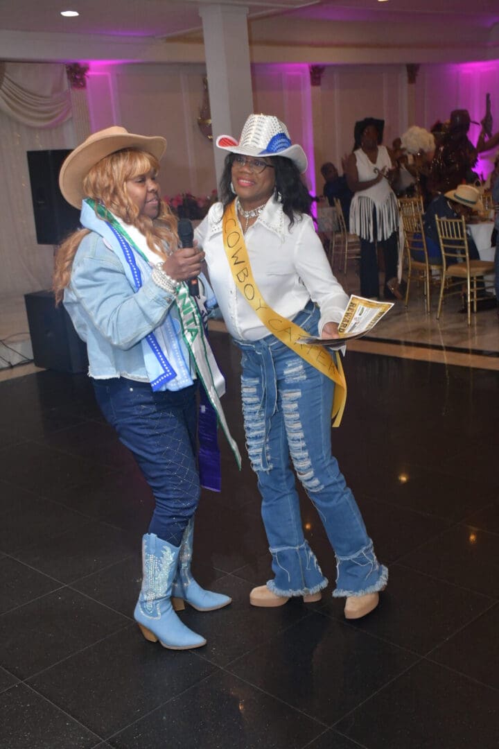 Two women in cowboy hats dancing indoors.