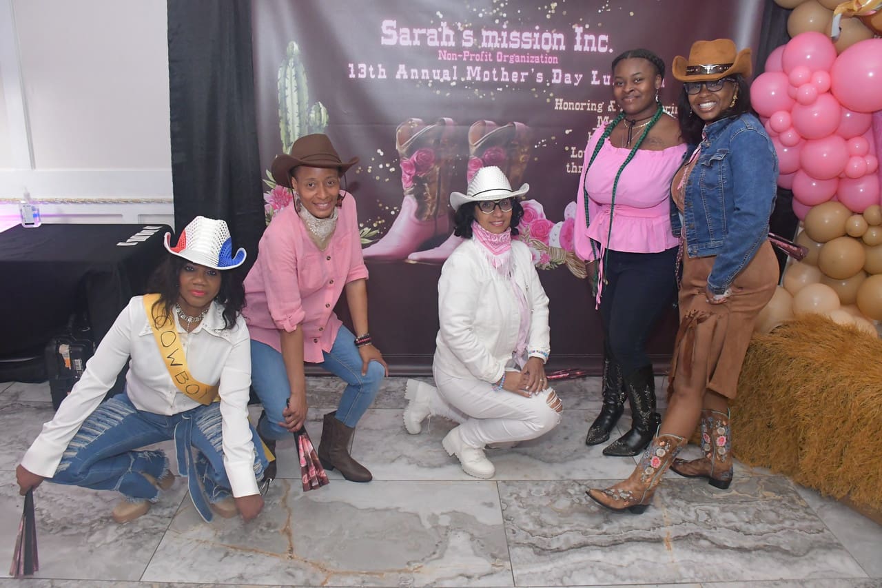 Five women in cowboy hats posing together.