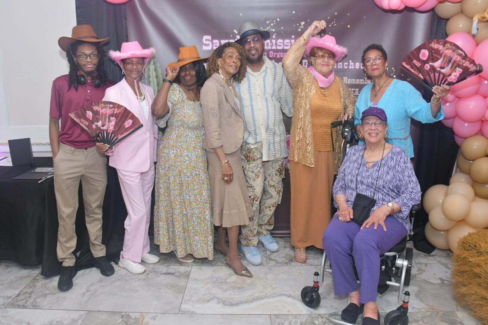 Group celebrating with hats and fans indoors.