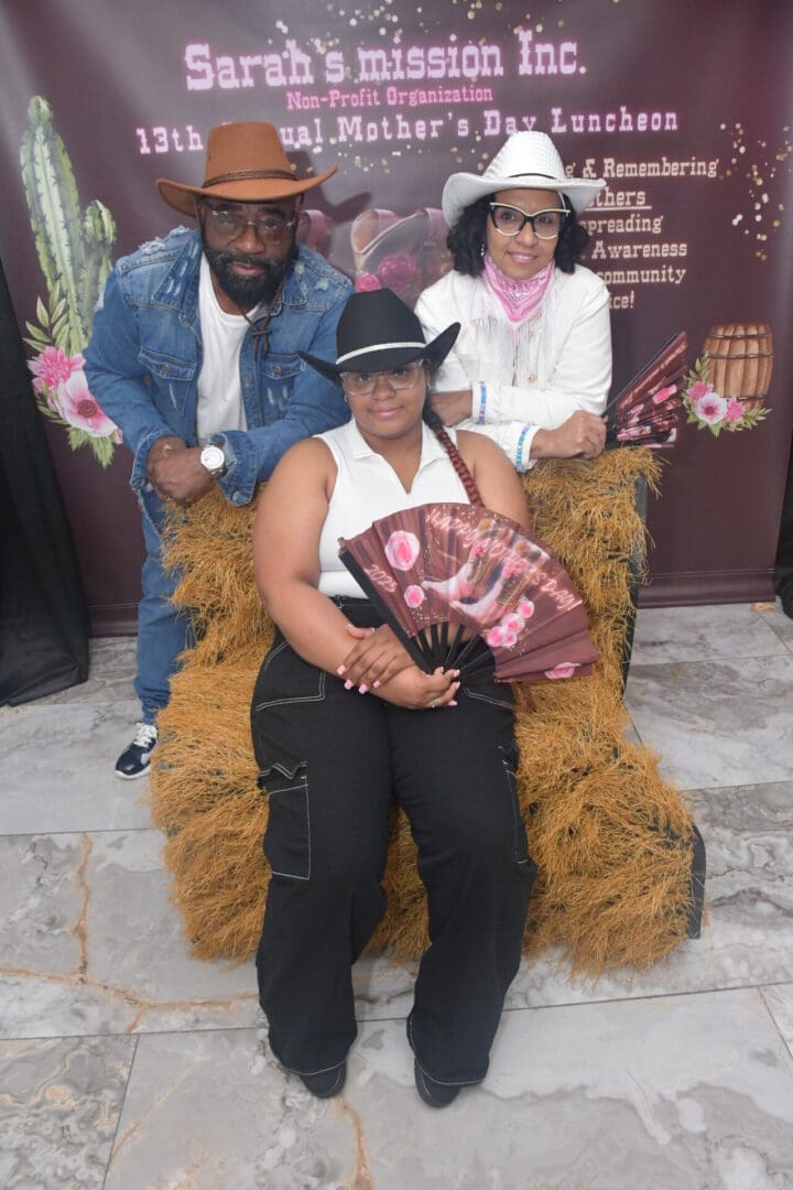 Three people in cowboy hats, smiling together.