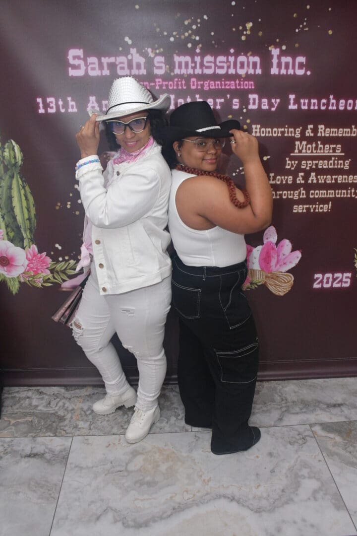 Two women posing in cowboy hats.