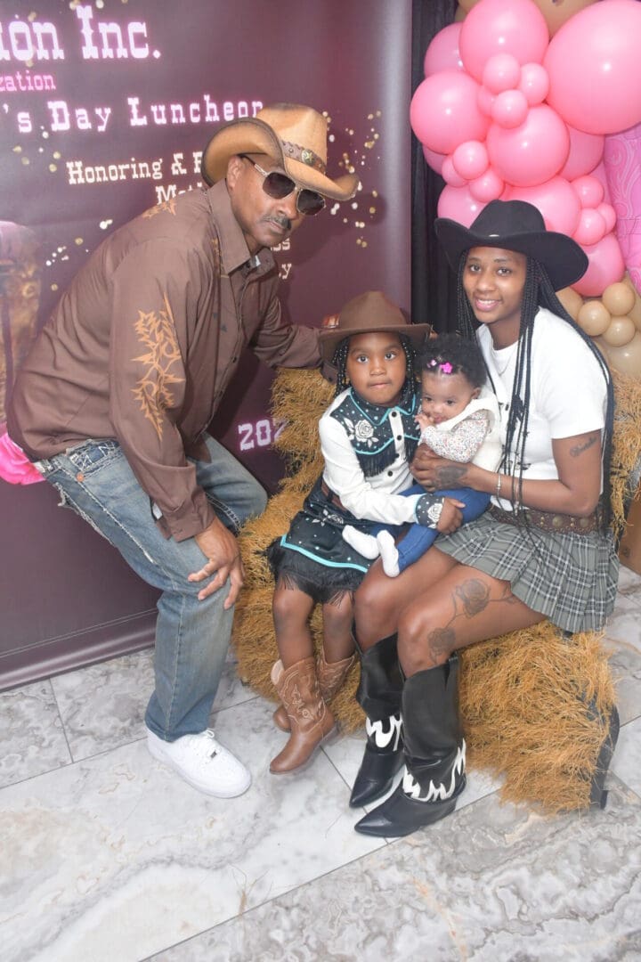 Family dressed in cowboy attire with balloons.