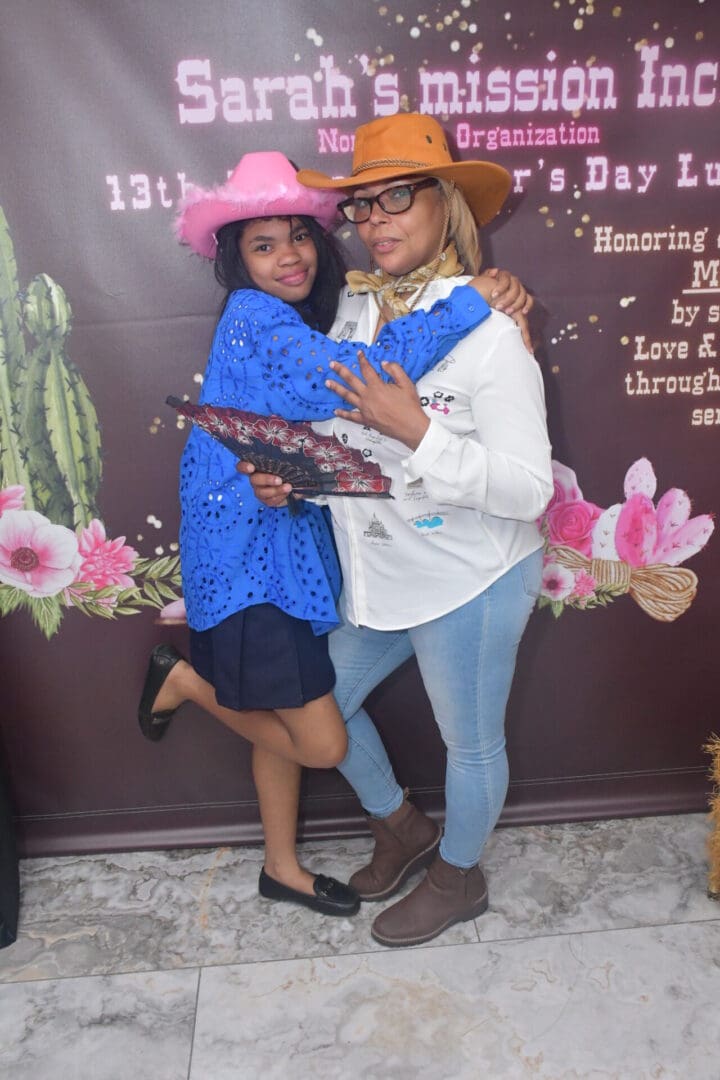 Two women posing in cowboy hats.