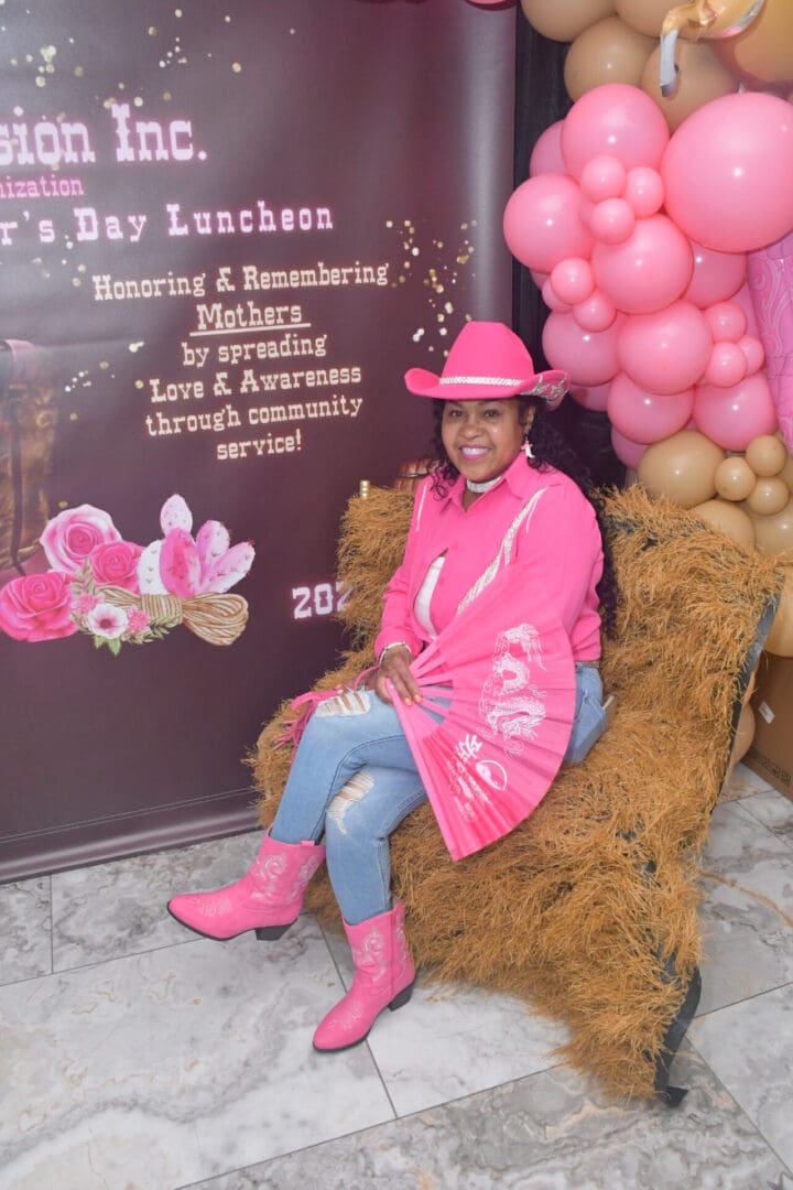 Woman in pink cowboy attire, smiling.