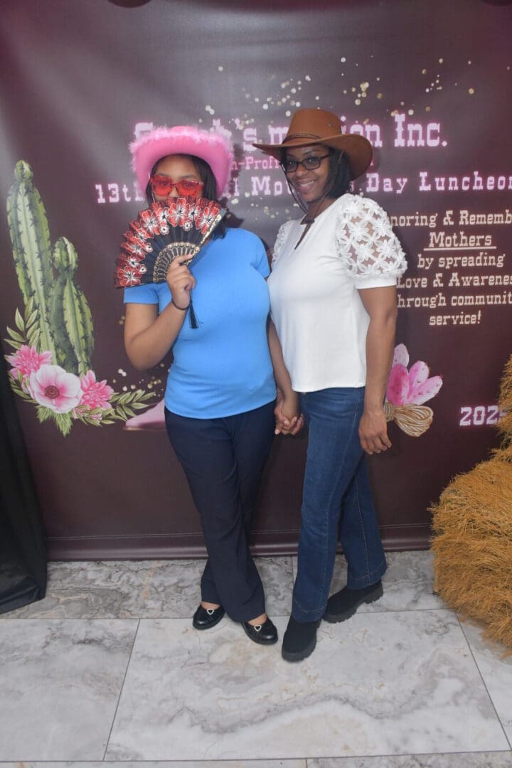 Two people posing with hats and fan.