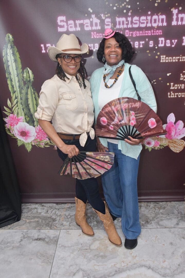 Two women posing with decorative fans.