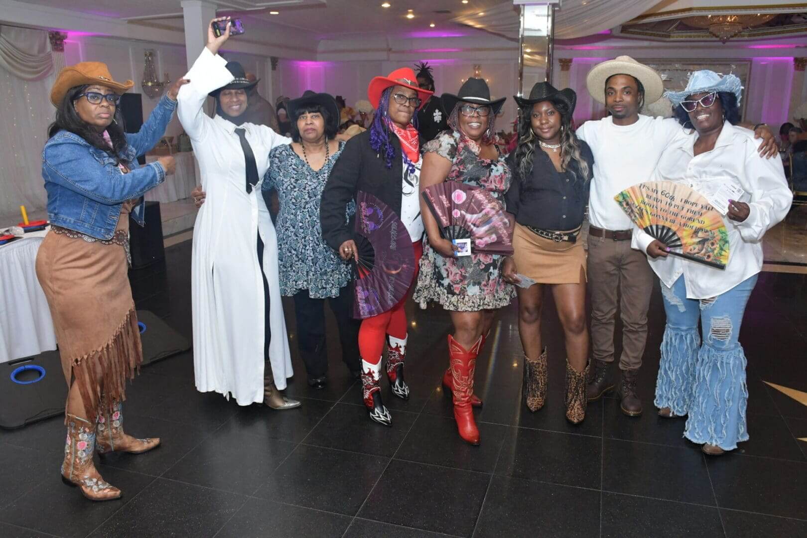 Group in cowboy-themed outfits at event.